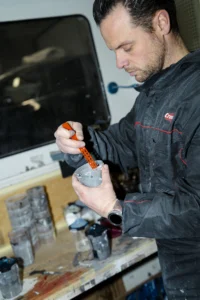Tony, carrossier chez ZeCarrossery prépare le vernis, c
