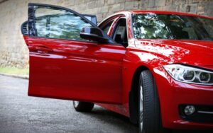 Voiture rouge prise de ce côté où on voit la portière d